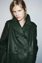 Blazer de piel color verde oscuro, de corte cruzado con doble botonadura negra, cuello solapa de muescas y manga larga.