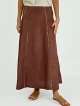 Pollera larga color marrón, de corte amplio y recto, con costuras verticales decorativas en blanco o hilo contrastante.