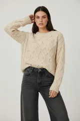 Sweater de chenille color beige, con punto trenzado, diseño holgado y cuello a la base.