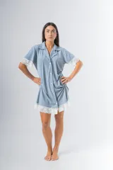 Camisa celeste con estampado a rayas verticales, de corte recto, con cuello camisero, cierre frontal con botones, mangas cortas con detalle de puntilla y ruedo con puntilla.