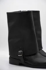 Bota de cuero color marrón oscuro con efecto desgastado, caña media, hebilla lateral y suela plana.