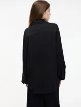 Camisa negra de viscosa con botones frontales y mangas largas.