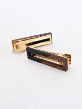 Set de dos broches para el pelo con diseño rectangular. Uno es de madera color marrón con una esquina negra, el otro es de madera color marrón con un borde negro.