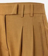 Pantalón de vestir color ocre, de corte recto, con cintura alta, bolsillos laterales y pinzas delanteras.