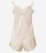 Conjunto de pijama compuesto por un top de satén color crema con lunares marrones, breteles finos regulables y escote en V con encaje, y un short con cintura elástica y estampado de lunares a juego.