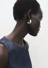 Top crop sin mangas, color azul oscuro, con cuello redondo y tirantes anchos. Presenta un efecto denim y cierre de botón en la parte trasera del cuello.