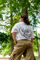 Remera blanca de corte holgado con estampado en la espalda de dos caras unidas por una línea.