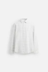 Camisa de vestir slim fit de algodón, color blanco con diseño de cuadros en tonos grises y beige. Tiene cuello italiano, mangas largas con puños abotonados y cierre frontal con botones.