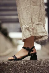 Sandalias negras de cuero charol, con tira delgada sobre los dedos y tira al tobillo con hebilla cuadrada. Taco bloque de 4 cm.