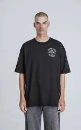 Remera negra de algodón con cuello redondo y calce oversize. Estampado en la espalda con diseño de la carta del tarot 'El Diablo', con figura femenina con cráneo de carnero sobre una pila de cráneos.