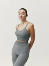 Top deportivo gris de sujeción media, con tecnología 3D y tirantes cruzados.