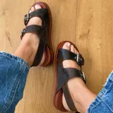 Sandalias de cuero color marrón con doble tira con hebilla ajustable, plantilla de cuero y suela de goma.