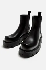 Bota Chelsea negra de cuero sintético, con elásticos laterales, tirador trasero y suela track.