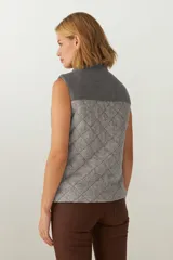 Chaleco corto de lana color marrón con diseño acolchado en forma de rombos. Presenta cuello alto, cierre frontal con cremallera dorada, dos bolsillos laterales y canesú en color marrón oscuro. Hecho en Uruguay.