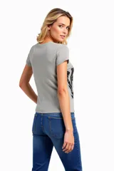 Remera de algodón ajustada al cuerpo, color azul, con estampado colorido en el frente.