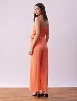 Enterito de crepe color naranja, marca Luxology. Escote en V cruzado, cintura elastizada con lazo de ajuste, espalda en punto smock y breteles de cadena.