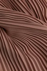 Pollera larga plisada color marrón, de tiro alto con elástico fino en la cintura y bajo sobrehilado con vuelo.