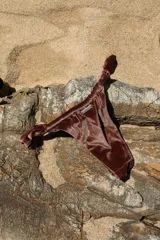 Bombacha de bikini confeccionada en lycra color blanco con rayas verticales color naranja.