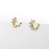 Par de argollas doradas con cristales claros irregulares, fabricadas en acero con baño en oro de 18k.