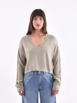 Sweater corto color beige con escote en V y mangas largas.