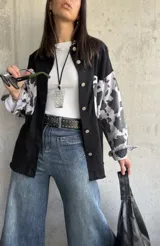 Sobrecamisa negra con mangas estampadas con diseño de vaca.