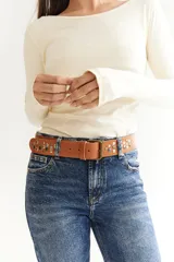 Cinto de cuero color marrón con hebilla metálica y tachas plateadas.