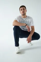 Remera color marrón con estampado rectangular con líneas horizontales y figura geométrica en el centro.