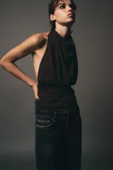 Top marrón con cuello halter, escote drapeado, detalle de pliegues y cierre trasero con cremallera oculta.