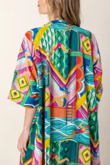 Vestido largo con estampado de peces azules sobre fondo blanco, cuello en V y mangas cortas.