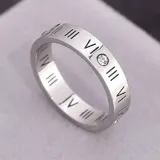 Anillo plateado de acero quirúrgico con números romanos grabados y una circonita engarzada.