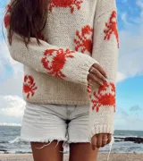 Sweater de lana merino color crudo con diseño de cangrejos rojos bordados a mano.