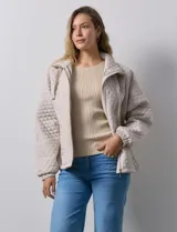 Campera beige capitoneada marca Weatherproof, con cierre central, bolsillos delanteros y forro interno.