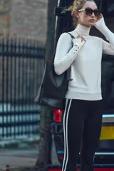 Jersey de punto color blanco, de cuello alto y manga larga con detalle de botones en el puño.