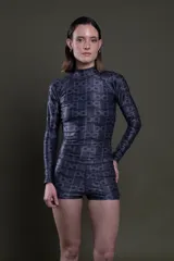 Remera polera de manga larga negra con estampado de letras en gris oscuro, confeccionada en lycra ajustada al cuerpo.