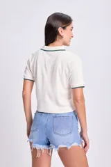 Camiseta de manga corta color blanco, de tejido rib, con cuello polo y botones.