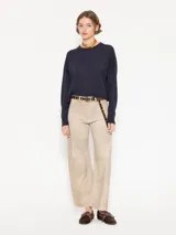 Sweater tejido suave y flojo, color crudo, con cuello redondo y mangas largas.