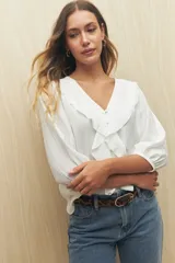 Blusa negra con mangas 3/4 y escote en V con volados.