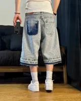 Bermuda de jean celeste matizado, corte baggy, con cordón ajustable en la cintura y detalle artesanal visible en el bajo.