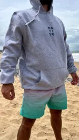 Hoodie gris oscuro con capucha y cordones ajustables. Estampado en la espalda con diseño de hojas en tonos naranja y rosa.