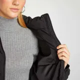 Campera puffer negra con diseño acolchado a rombos, cuello alto y cierre frontal.
