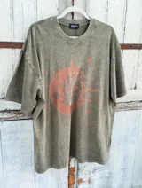 Remerón gris de corte oversize con estampado de sol, luna y estrellas en color naranja.