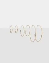 Set de tres pares de aros tipo argolla de metal dorado en diferentes tamaños, con cierre de tope a presión.