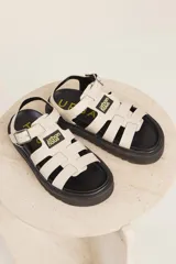 Sandalias de cuero sintético color lila con plataforma negra y tiras anchas cruzadas.