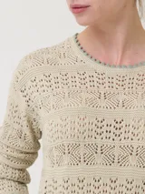 Sweater color crema de punto calado, con cuello redondo y mangas largas. Presenta detalles de crochet en cuello, puños y ruedo.