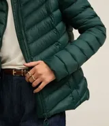 Campera puffer ultraligera color marrón, confeccionada en poliamida acolchada, con cuello alto y cierre por cremallera. Incluye bolsita con cordón.