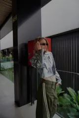 Pantalón ancho verde oliva con bolsillos cargo y aplique de cinta con rayas blancas en los laterales.