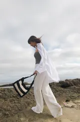 Cartera tejida a crochet con hilo 100% de algodón, con diseño a rayas y volados bordeando la cartera extendiéndose hacia la manija.