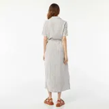 Vestido largo camisero a rayas verticales grises y blancas, con cuello camisero, mangas cortas y lazo en la cintura.