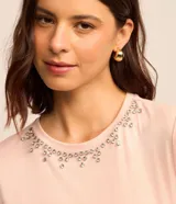 Blusa rosa de viscosa con cuello redondo, mangas cortas y detalles de strass en el cuello.