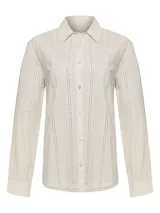 Blusa color crema de manga larga con cuello clásico y cierre frontal con botones. Presenta detalles de calado vertical en el frente y las mangas.